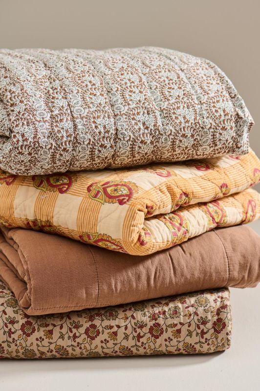 Quiltet pledd med orange og rødt blokkmønster